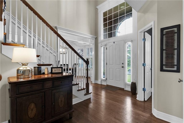 21511 W 100th Ter, Lenexa, KS 66220 - entryway featuring stairway, dark wood-style flooring, a towering ceiling, and baseboards
