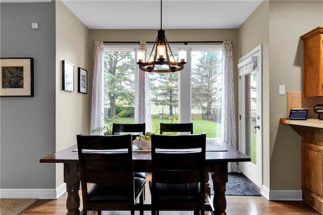 21511 W 100th Ter, Lenexa, KS 66220 - dining space with a chandelier, baseboards, and wood finished floors
