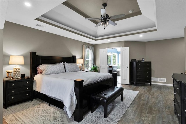 21511 W 100th Ter, Lenexa, KS 66220 - bedroom featuring a raised ceiling, wood finished floors, baseboards, connected bathroom, and recessed lighting