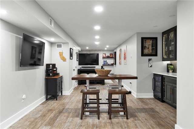 21511 W 100th Ter, Lenexa, KS 66220 - dining space featuring wine cooler, recessed lighting, light wood-style floors, baseboards, and a bar
