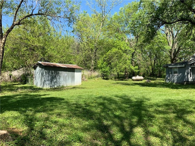 8480 NW High St Unit B, Amsterdam, MO 64723 - view of yard featuring a storage shed, a view of trees, and an outdoor structure