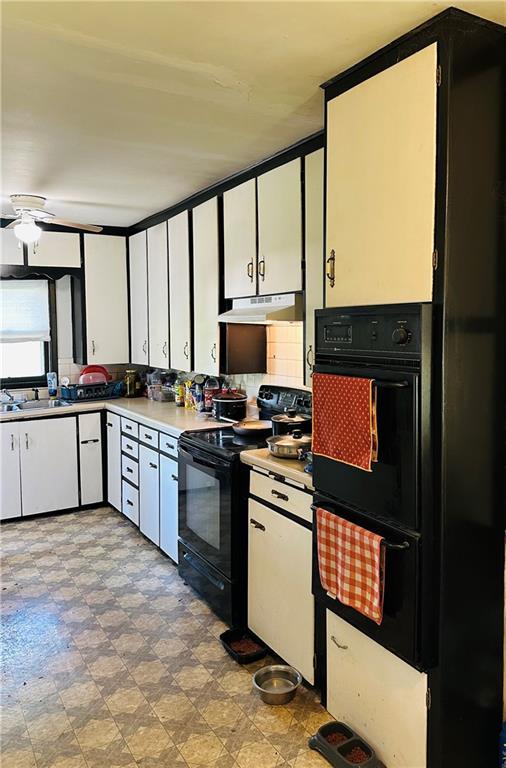 8480 NW High St Unit B, Amsterdam, MO 64723 - kitchen with a ceiling fan, under cabinet range hood, white cabinets, a sink, and black appliances