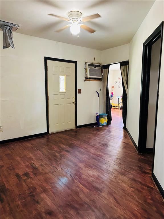 8480 NW High St Unit B, Amsterdam, MO 64723 - foyer entrance featuring baseboards, a ceiling fan, an AC wall unit, and wood finished floors