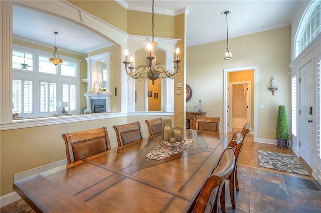2945 W 143rd Ter, Leawood, KS 66224 - dining area featuring a fireplace, crown molding, baseboards, a chandelier, and stone finish flooring
