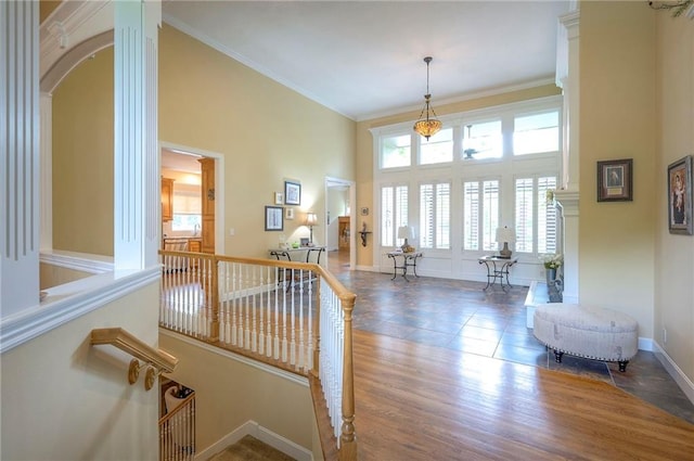 2945 W 143rd Ter, Leawood, KS 66224 - stairway with a towering ceiling, ornate columns, baseboards, ornamental molding, and wood finished floors