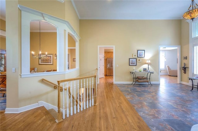 2945 W 143rd Ter, Leawood, KS 66224 - hall with an upstairs landing, a chandelier, baseboards, a high ceiling, and crown molding