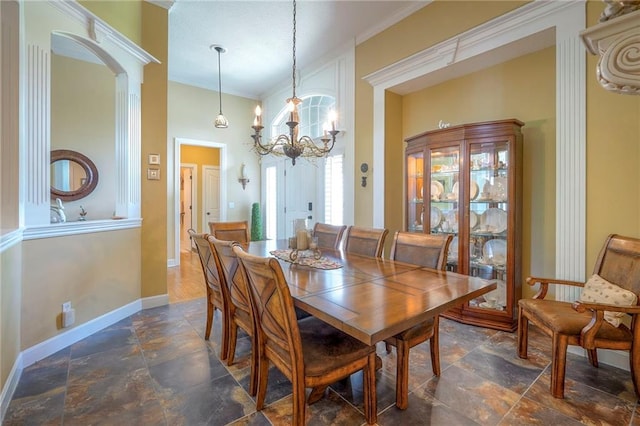 2945 W 143rd Ter, Leawood, KS 66224 - dining space featuring stone tile flooring, a chandelier, baseboards, ornamental molding, and arched walkways