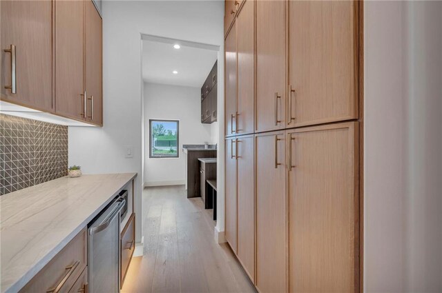 2621 NW 84th Pl, Kansas City, MO 64154 - kitchen featuring backsplash, light stone counters, light brown cabinetry, and light wood-style floors