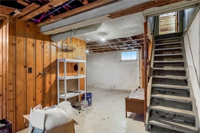 basement with stairs and wooden walls
