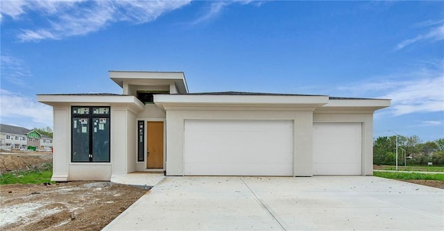 2611 NW 84th Ter, Kansas City, MO 64154 - prairie-style house with a garage, stucco siding, and concrete driveway