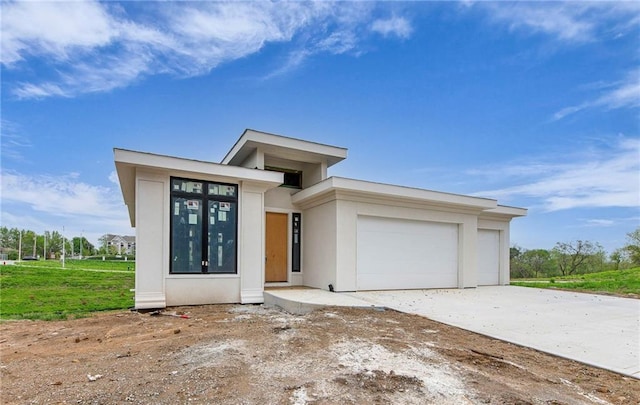 2611 NW 84th Ter, Kansas City, MO 64154 - prairie-style house with an attached garage, driveway, and stucco siding