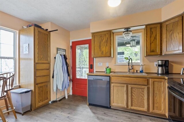 kitchen with a sink, electric stove, brown cabinets, and dishwasher