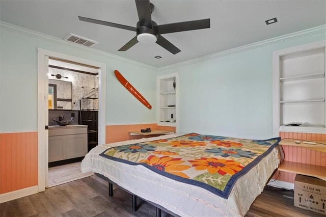 bedroom with crown molding, wainscoting, and visible vents