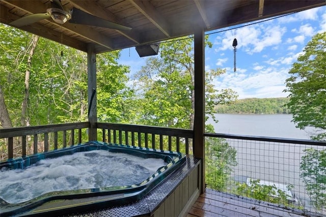 wooden deck featuring a water view, a hot tub, and ceiling fan