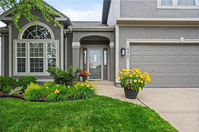 18461 W 157th St, Olathe, KS 66062 - doorway to property with stucco siding, driveway, a yard, and a garage