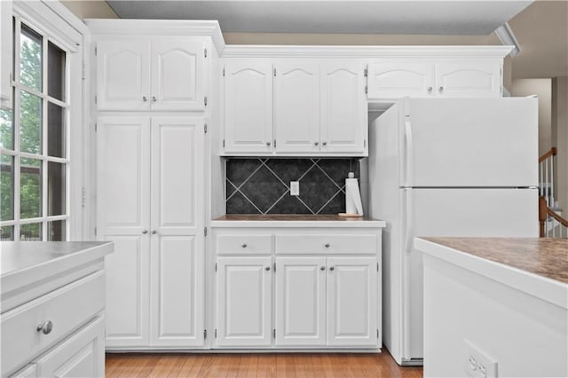 18461 W 157th St, Olathe, KS 66062 - kitchen featuring freestanding refrigerator, white cabinetry, decorative backsplash, and plenty of natural light