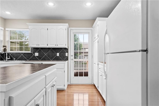 18461 W 157th St, Olathe, KS 66062 - kitchen with freestanding refrigerator, dark countertops, plenty of natural light, light wood-style floors, and recessed lighting