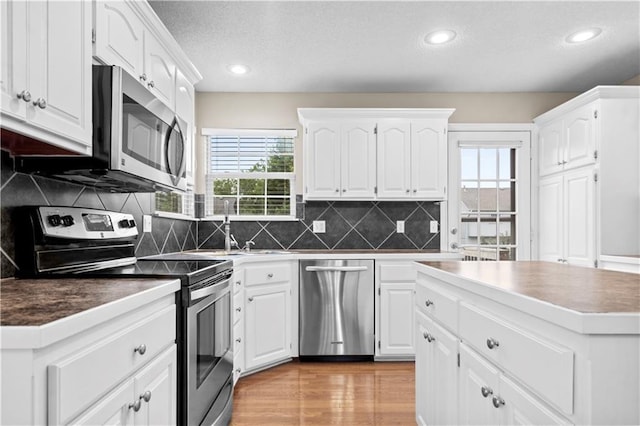 18461 W 157th St, Olathe, KS 66062 - kitchen with stainless steel appliances, healthy amount of natural light, a textured ceiling, white cabinets, and recessed lighting