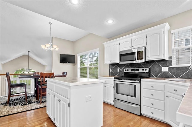 18461 W 157th St, Olathe, KS 66062 - kitchen with appliances with stainless steel finishes, light wood-style floors, a chandelier, a kitchen island, and lofted ceiling
