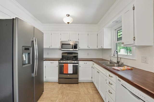 8020 Yecker Ave, Kansas City, KS 66109 - kitchen with appliances with stainless steel finishes, a sink, white cabinets, and ornamental molding