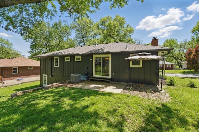 8020 Yecker Ave, Kansas City, KS 66109 - rear view of house with board and batten siding, a chimney, central AC unit, and a patio area