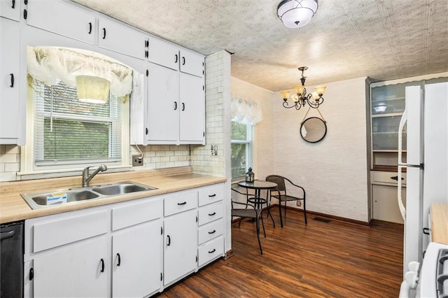 kitchen with a sink, dark wood-style floors, a chandelier, light countertops, and white cabinetry