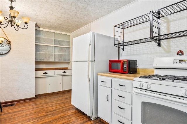 kitchen featuring white appliances, a chandelier, dark wood-type flooring, light countertops, and white cabinetry