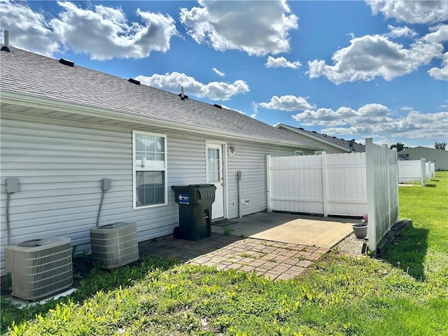 rear view of house featuring central air condition unit, a patio area, roof with shingles, and fence