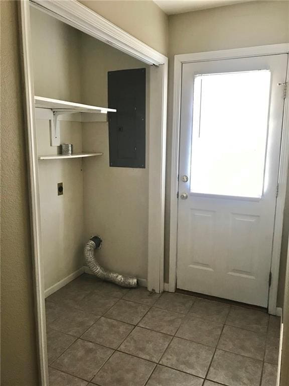 washroom featuring electric panel, laundry area, light tile patterned floors, and hookup for an electric dryer