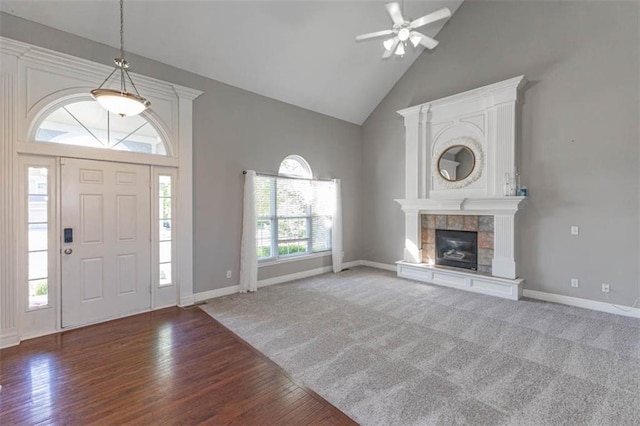 8115 NE 112th St, Kansas City, MO 64157 - carpeted foyer entrance with high vaulted ceiling, ceiling fan, wood finished floors, a tiled fireplace, and baseboards