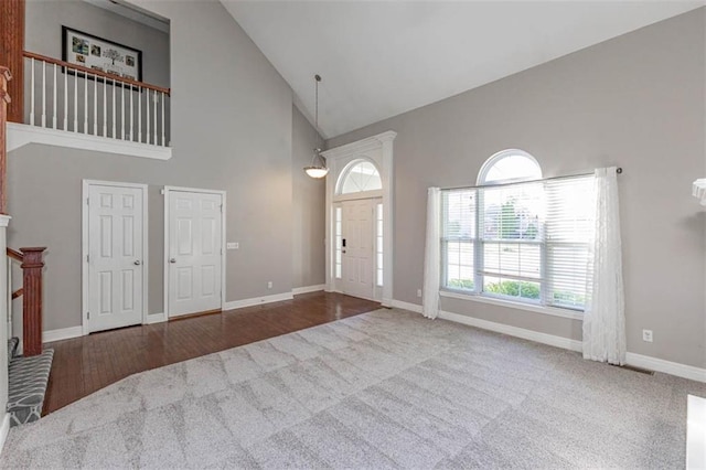 8115 NE 112th St, Kansas City, MO 64157 - carpeted foyer with high vaulted ceiling, baseboards, and wood finished floors
