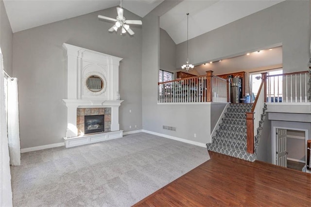 8115 NE 112th St, Kansas City, MO 64157 - unfurnished living room featuring high vaulted ceiling, stairs, ceiling fan, a chandelier, and a fireplace