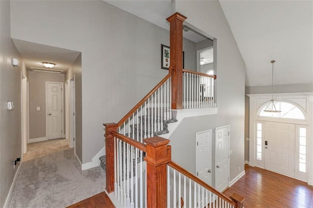 8115 NE 112th St, Kansas City, MO 64157 - entryway with high vaulted ceiling, baseboards, wood finished floors, stairway, and decorative columns