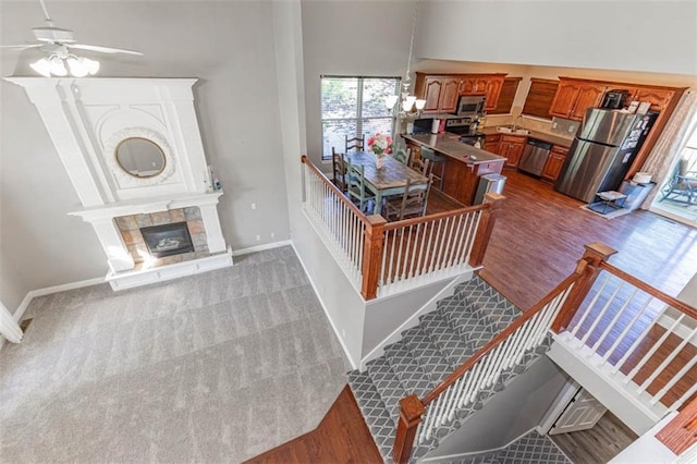 8115 NE 112th St, Kansas City, MO 64157 - stairs with baseboards, ceiling fan, wood finished floors, and a tile fireplace