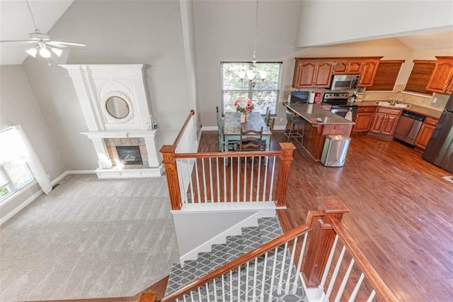 8115 NE 112th St, Kansas City, MO 64157 - stairs with high vaulted ceiling, a chandelier, healthy amount of natural light, ceiling fan, and a glass covered fireplace