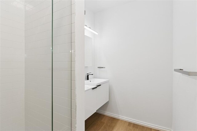 10924 W 67th St, Shawnee, KS 66203 - bathroom with wood finished floors, baseboards, and vanity