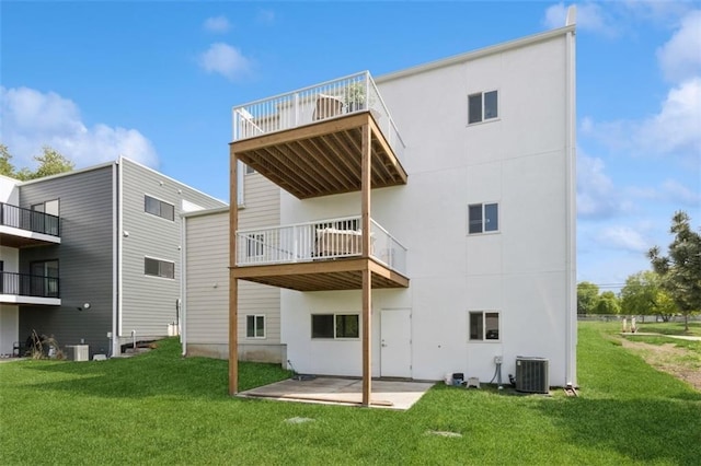 10924 W 67th St, Shawnee, KS 66203 - back of property featuring central air condition unit, a balcony, a lawn, and a patio area