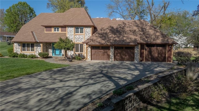 view of front facade featuring stone siding, an attached garage, driveway, and a front lawn