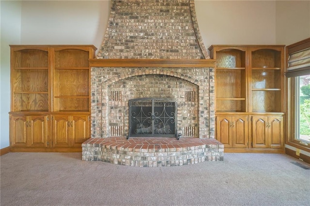 unfurnished living room with carpet and a fireplace