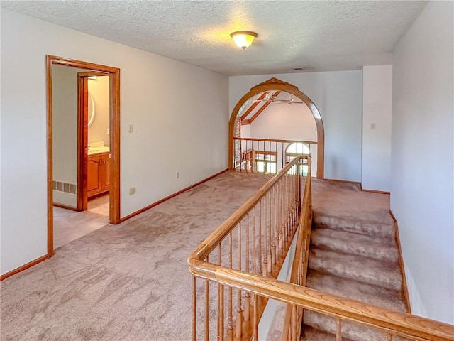 stairs with carpet floors, a textured ceiling, and baseboards