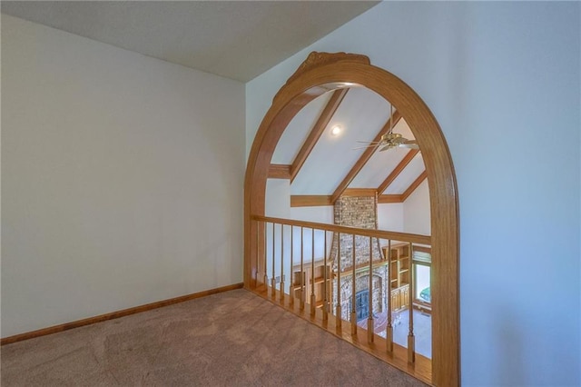 carpeted empty room featuring ceiling fan, baseboards, and vaulted ceiling