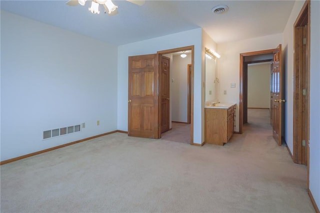 unfurnished bedroom featuring light carpet, baseboards, and a ceiling fan