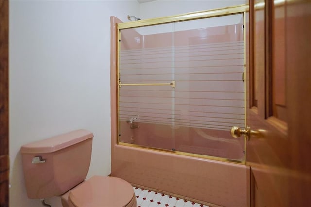 full bath featuring toilet and combined bath / shower with glass door