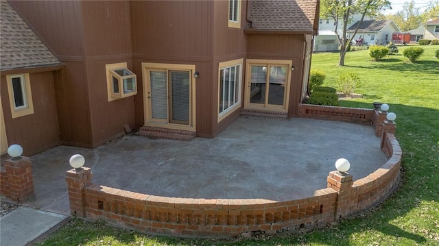 back of property with a patio, a yard, and a shingled roof