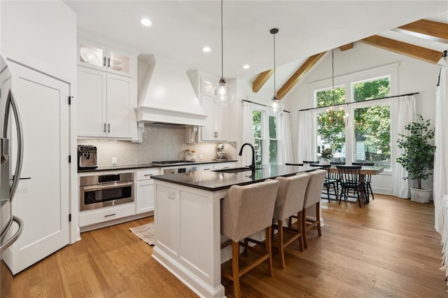2704 W 74th St, Prairie Village, KS 66208 - kitchen featuring appliances with stainless steel finishes, dark countertops, a sink, backsplash, and custom range hood