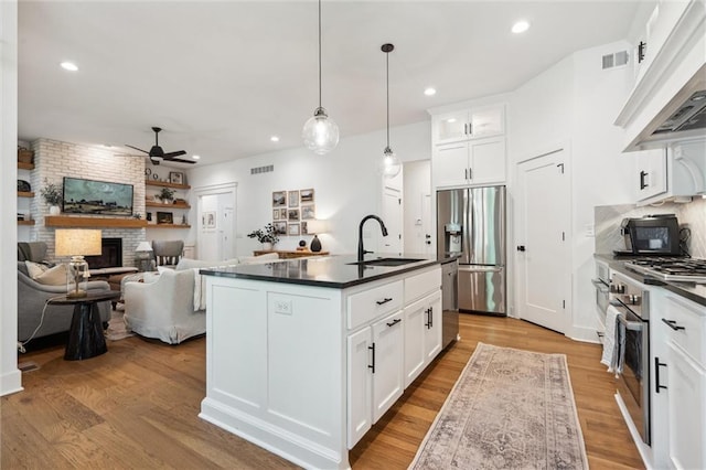 2704 W 74th St, Prairie Village, KS 66208 - kitchen with a sink, appliances with stainless steel finishes, a ceiling fan, dark countertops, and light wood finished floors