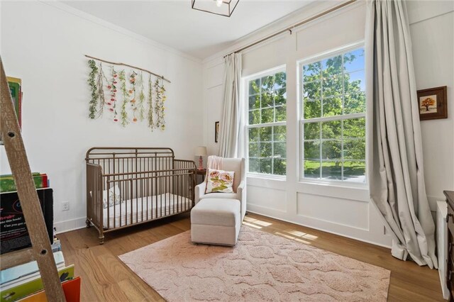 2704 W 74th St, Prairie Village, KS 66208 - bedroom featuring a crib, crown molding, and wood finished floors
