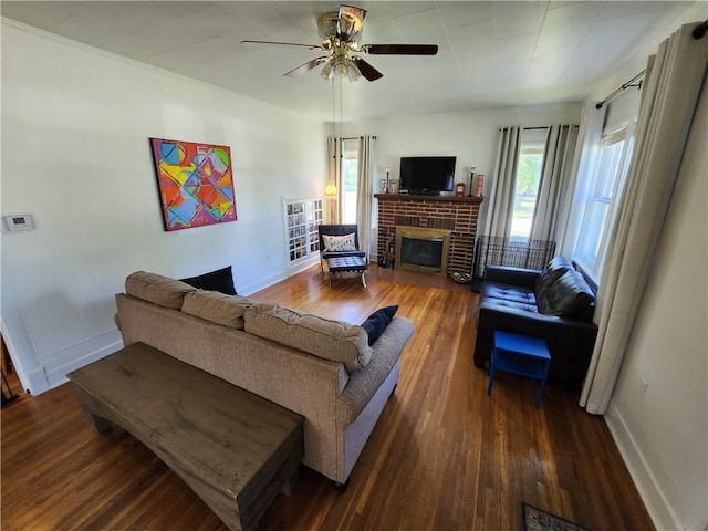 living area featuring baseboards, a fireplace, a ceiling fan, and hardwood / wood-style flooring
