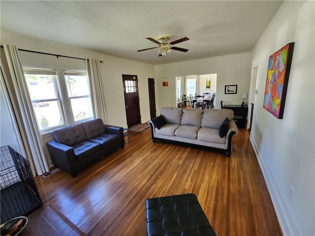 living room with baseboards, visible vents, ceiling fan, and wood finished floors