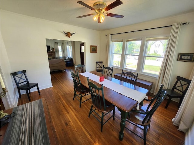 dining area featuring baseboards, ceiling fan, and wood finished floors